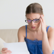 young woman reading a bill with a WTF look on her face
